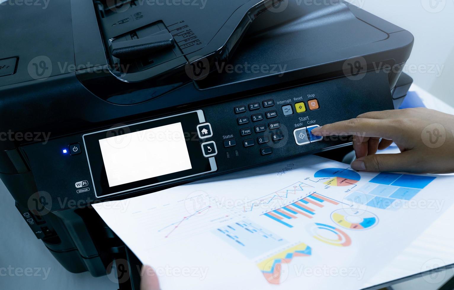 Office worker prints paper on multifunction laser printer. Copy, print