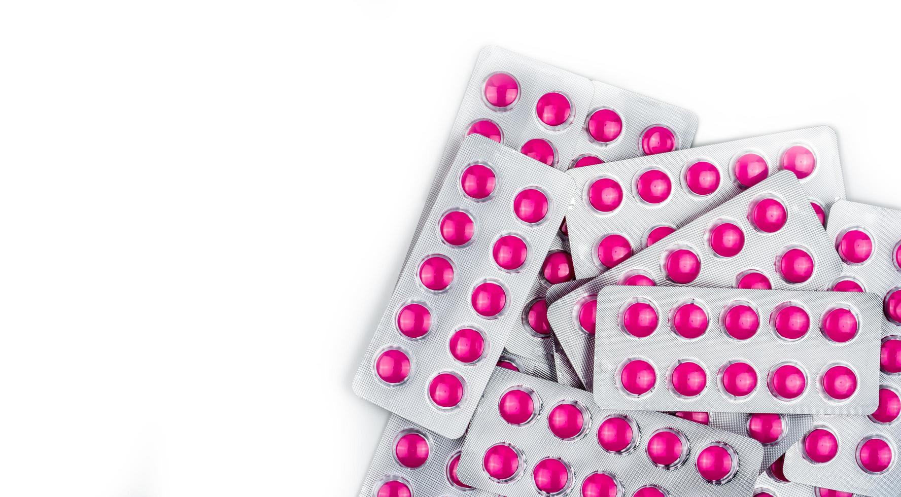 Top view of round pink tablets pills in blister packs on white background with copy space. Ibuprofen tablets pills for relief pain, high fever, headache, toothache and wound inflammation photo