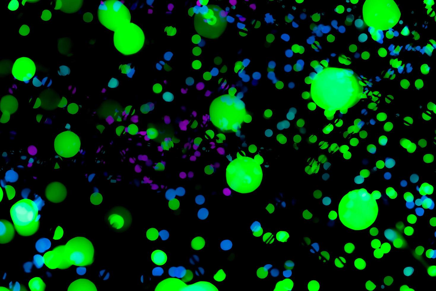Christmas and happy new year decoration light. Neon green, blue, purple color bokeh background with beautiful pattern. Defocused Xmas light in the night of party. Christmas holiday bokeh background. photo