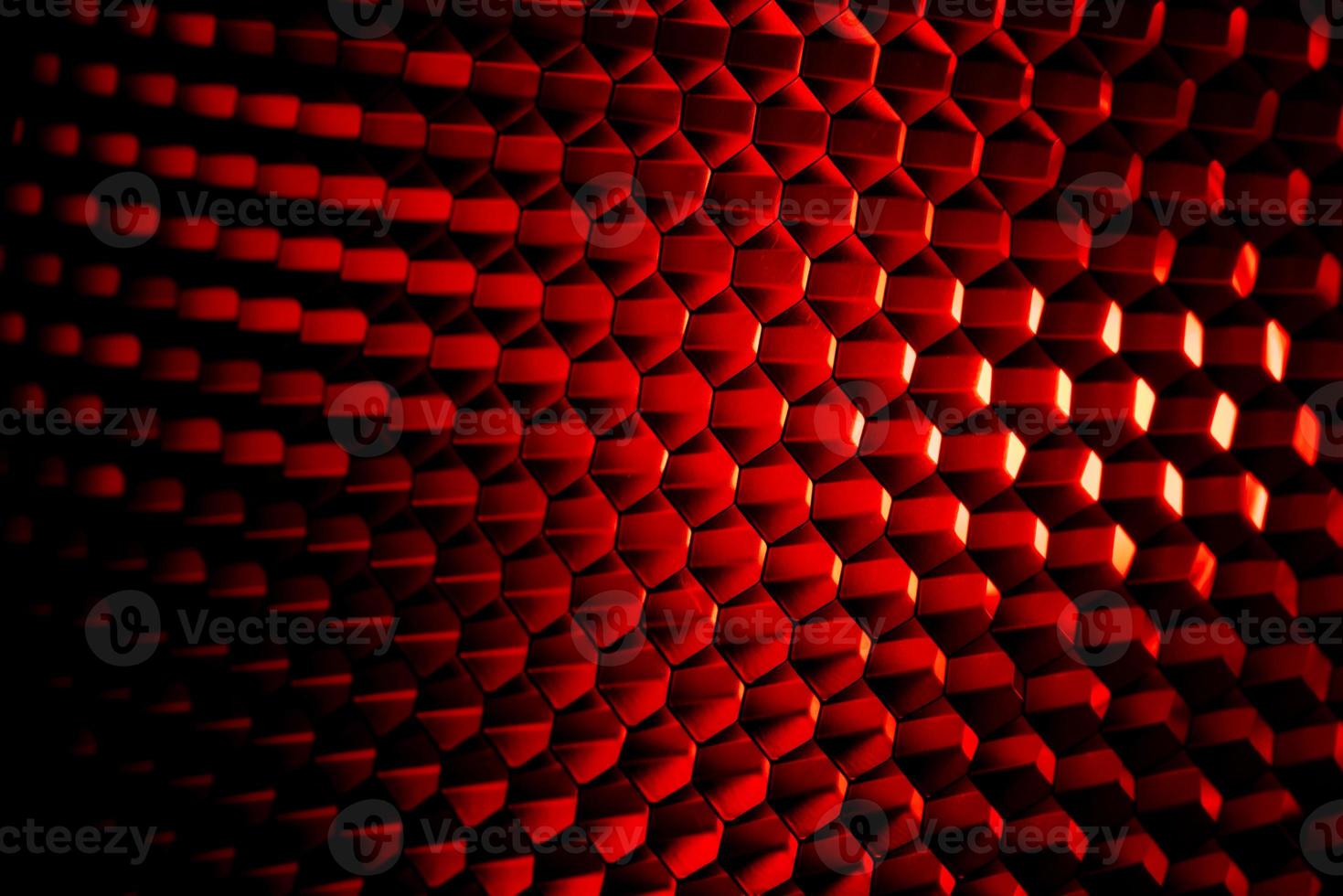 Closeup honeycomb grid texture with red light. Red and dark metal hexagon shaped pattern abstract background. Light modifier equipment. Metal honeycomb. Futuristic pattern. Honey grid cells network. photo