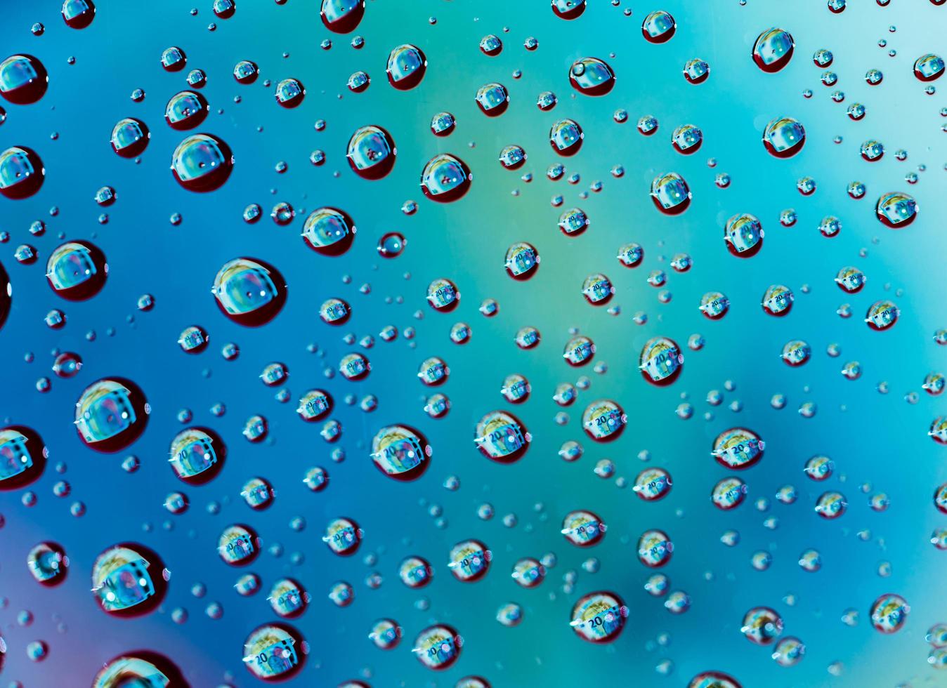 Macro shot detail reflection of 20 Euro banknote in water drops. Colorful water drops background photo