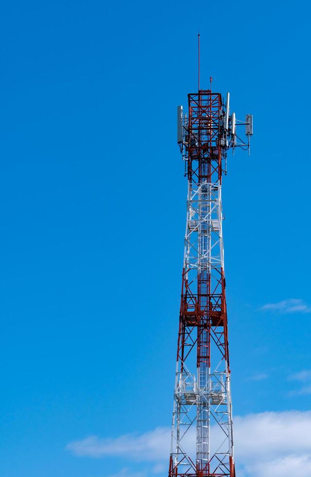 Telecommunication tower with blue sky and white clouds background. Antenna on blue sky. Radio and satellite pole. Communication technology. Telecommunication industry. Mobile or telecom 4g network. photo