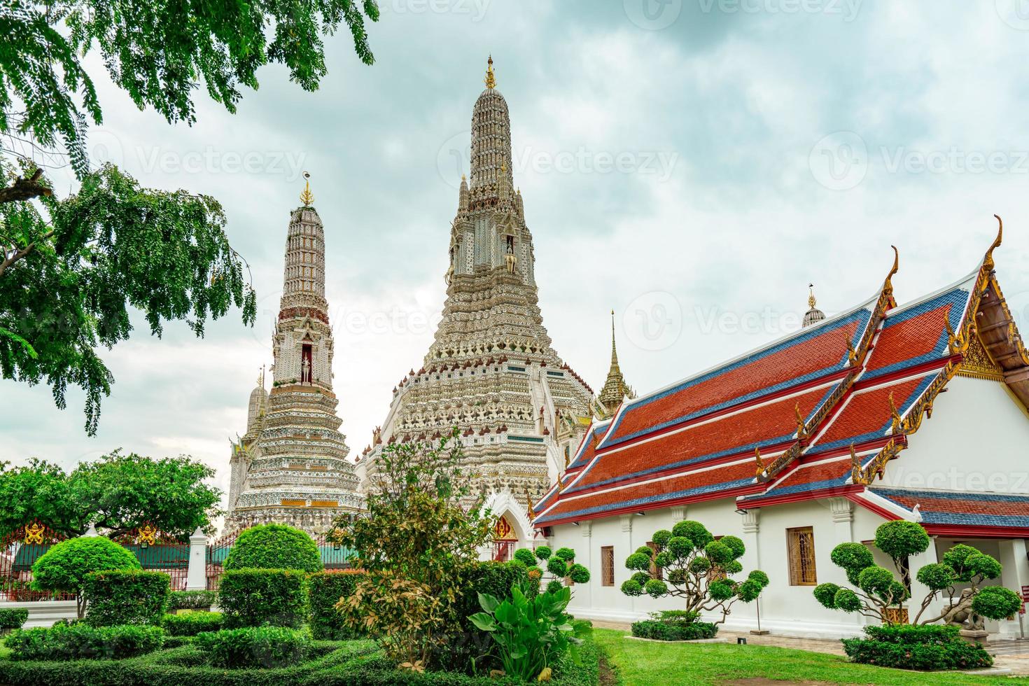 Wat Arun Ratchawararam with beautiful blue sky and white clouds. Wat Arun buddhist temple is the landmark in Bangkok, Thailand. Attraction art and ancient architecture in Bangkok, Thailand. photo