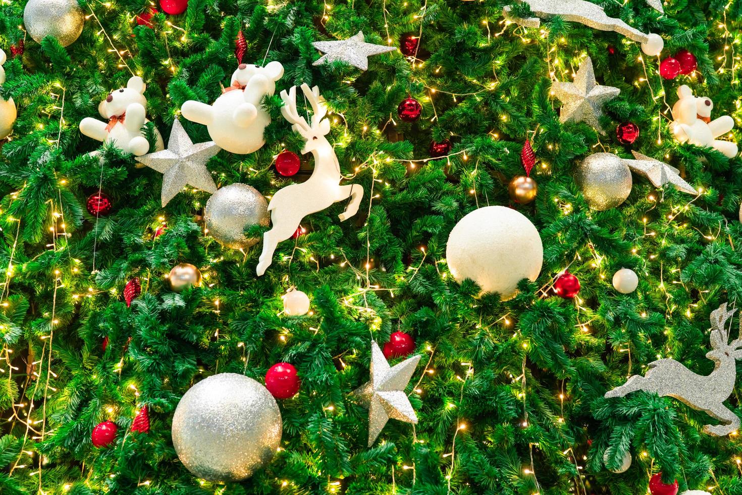 Close up Christmas tree decoration with red, gold, silver, and white balls, silver star and white reindeer. Xmas background. Christmas and Happy New Year background. Colorful ball on Christmas tree. photo