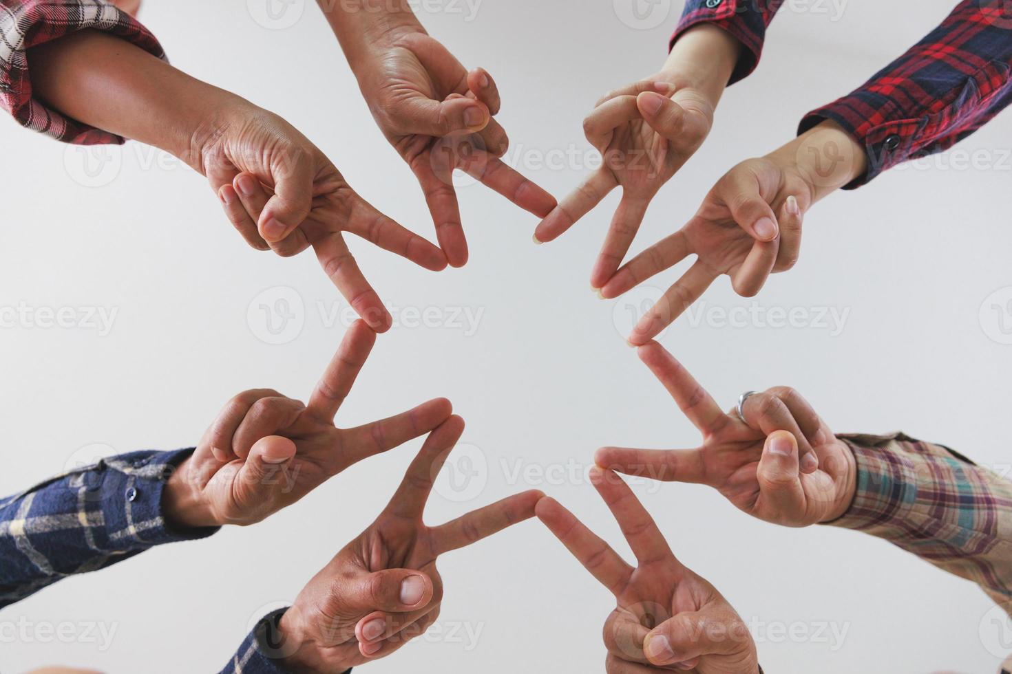 A diverse group of people connects their hands as a supportive sign expressing a sense of teamwork. Unity and togetherness. photo