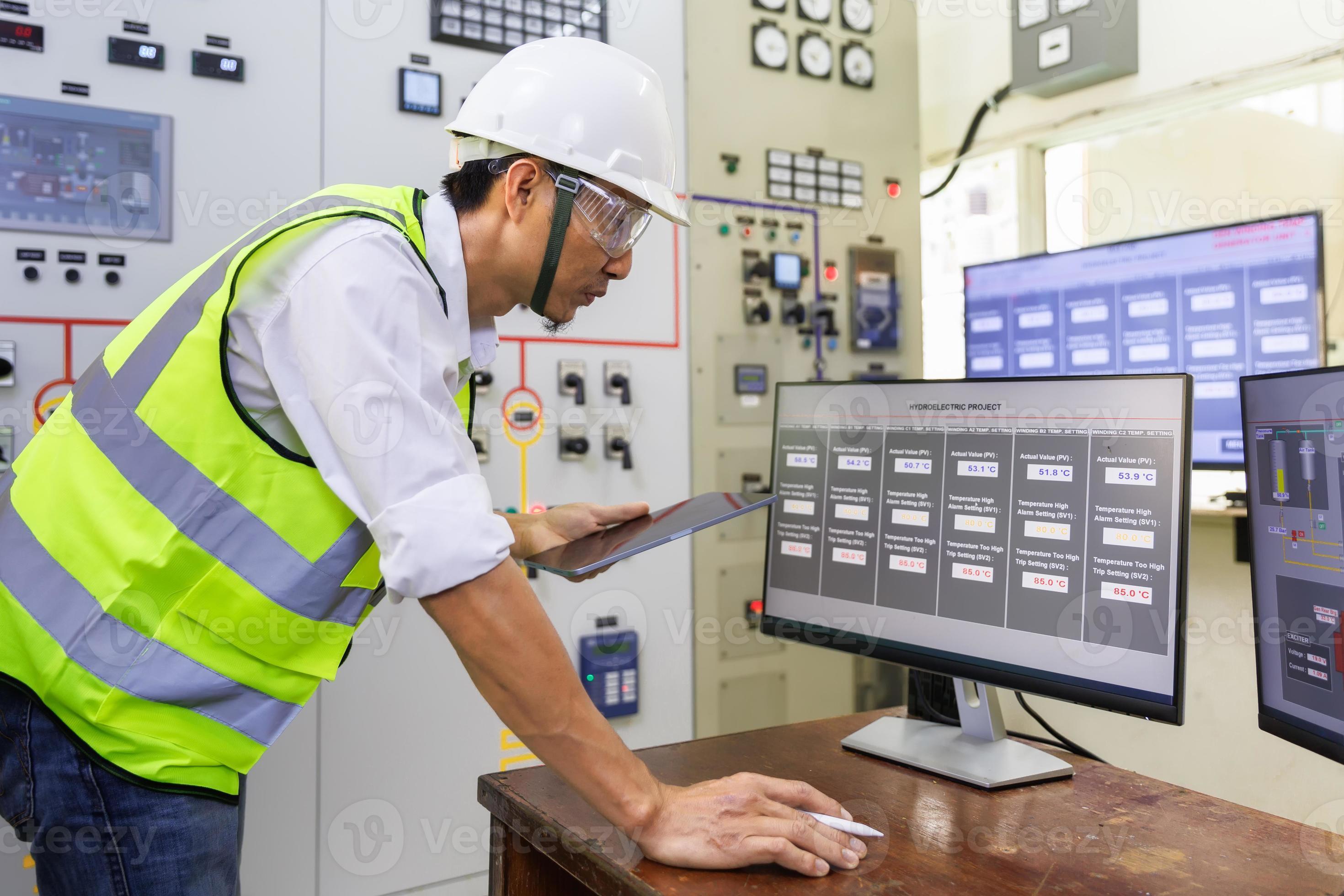 Experienced electrician working in a power plant control room. Engineer