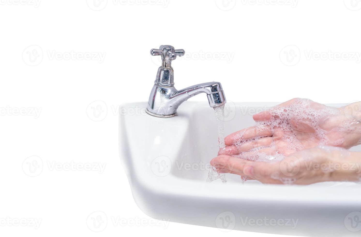 Woman washing hand with soap foam and tap water in bathroom. Hand clean under faucet on sink for personal hygiene to prevent flu and coronavirus. Good procedure of hand wash to kill bacteria, virus. photo