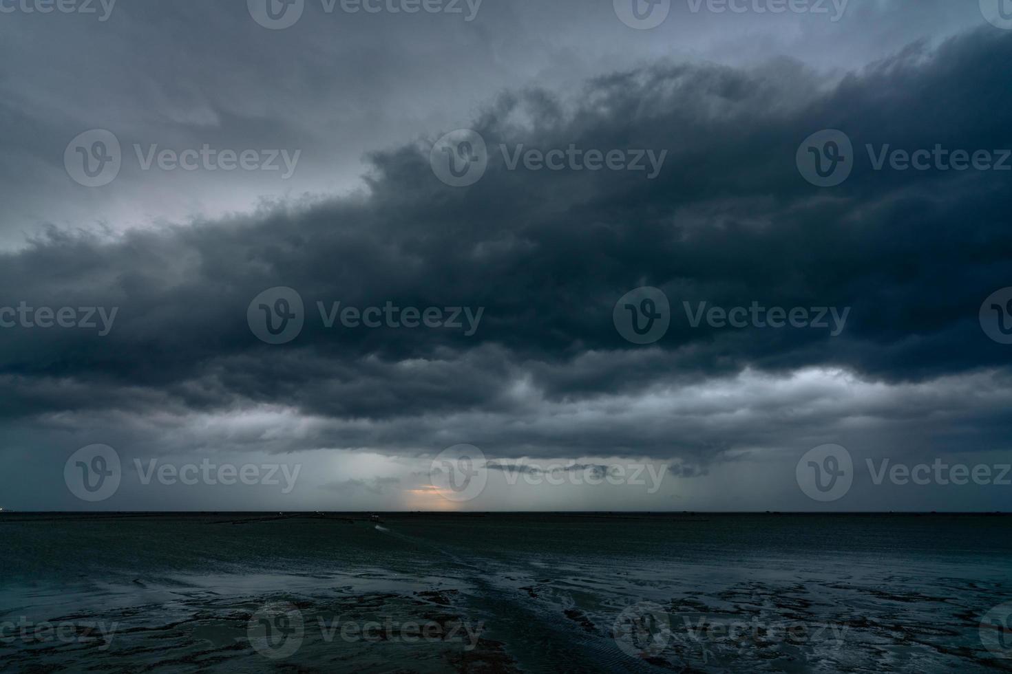 Landscape view of sea at tide and silhouette dark dramatic sunset sky and clouds in the evening. Sunset sky of tropical beach. Beauty in nature. Dark background for sad, death, and depression. photo