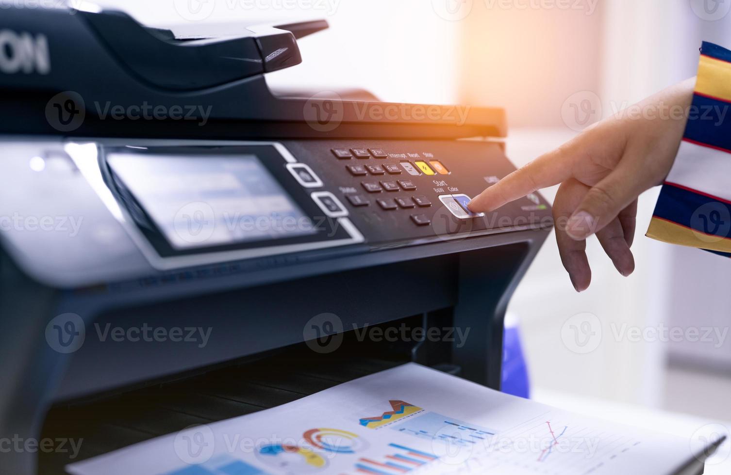 Office worker print paper on multifunction laser printer. Copy, print, scan, and fax machine in office. Modern print technology.  Photocopy machine. Document and paper work. Professional scanner. photo