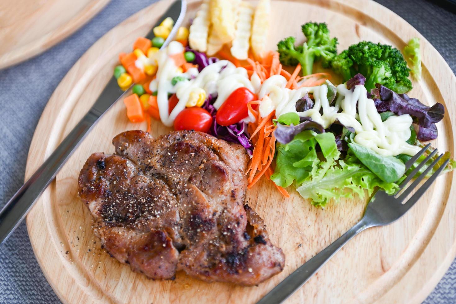 Steak homemade with french fries and fresh vegetable salad on wooden tray, healthy steak menu, Steak pork photo