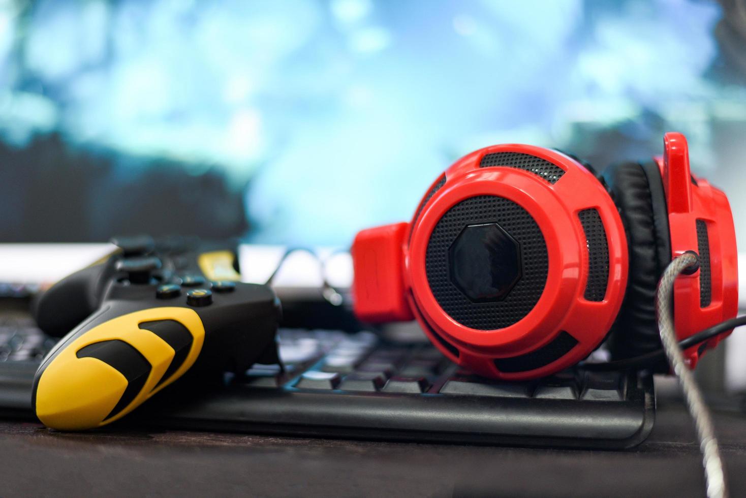 joystick de game pad y auriculares en el teclado jugando juegos y viendo videos en la televisión o en la consola de juegos de computadora foto