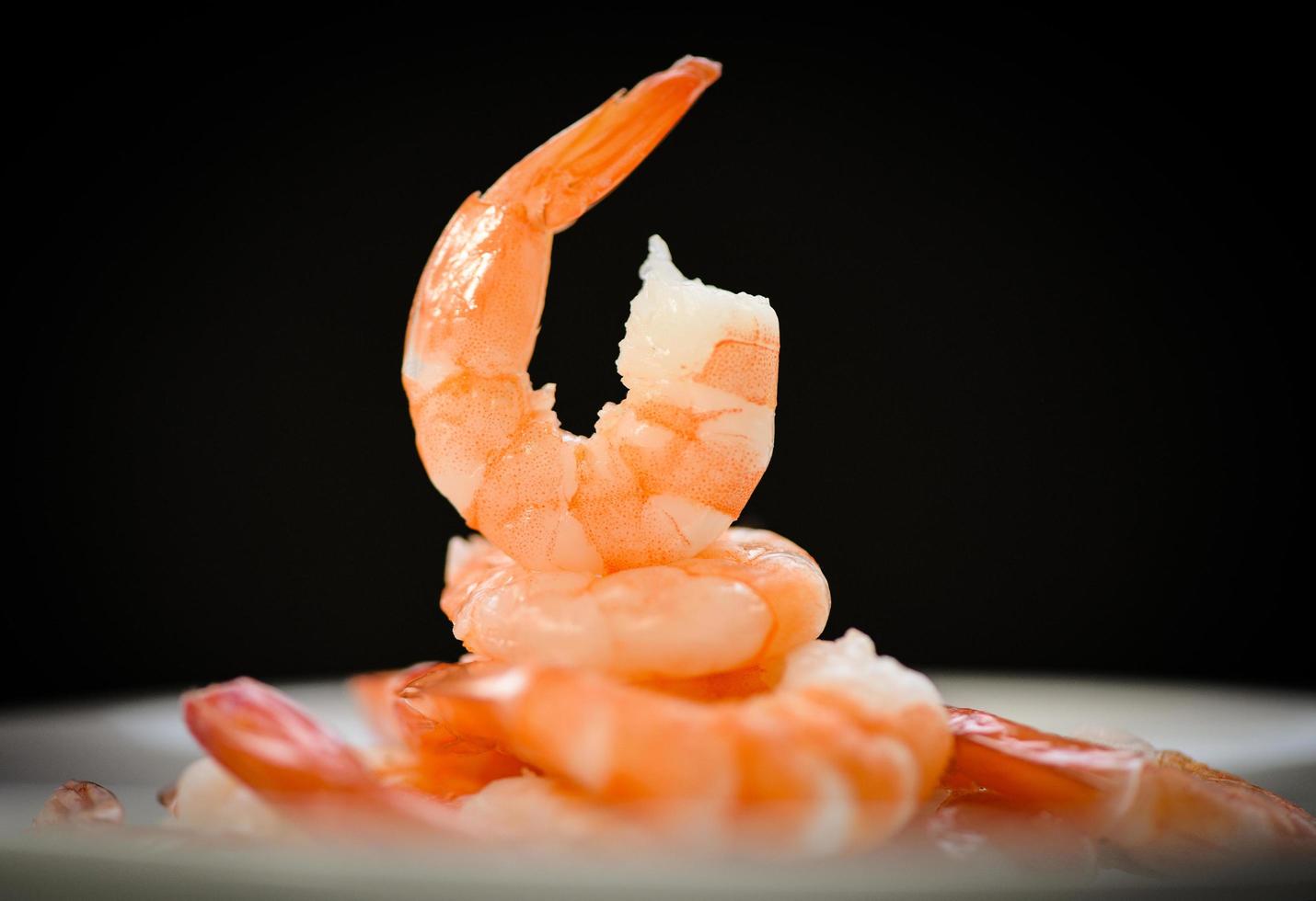 Decorate dining table food shrimps prawns boiled cooked seafood on dark black background - beautiful shrimp photo