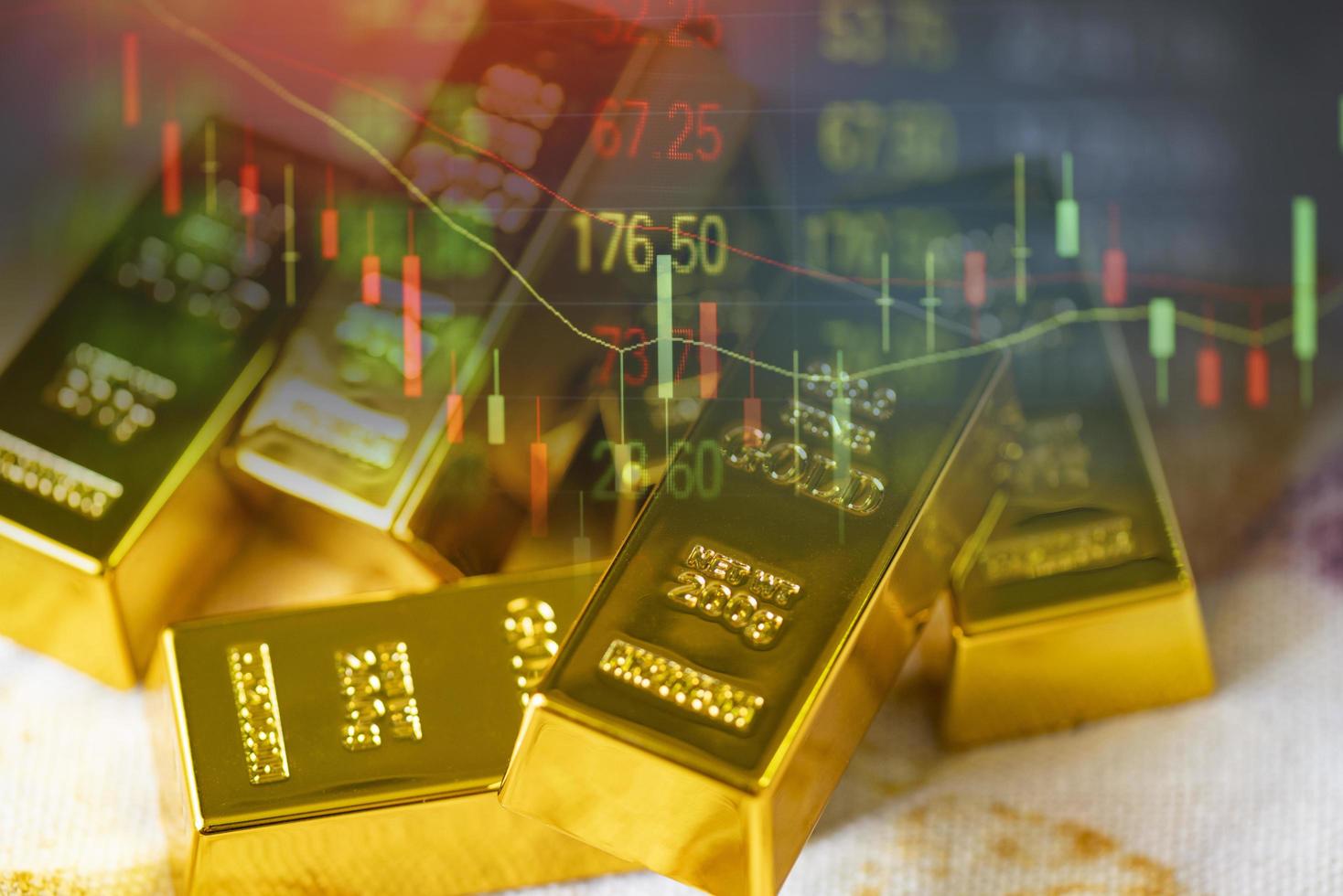 Gold trading, gold bars on fabric with stock graph chart stock market trade background, pile of gold bars financial business economy concepts, wealth and reserve success in business and finance photo