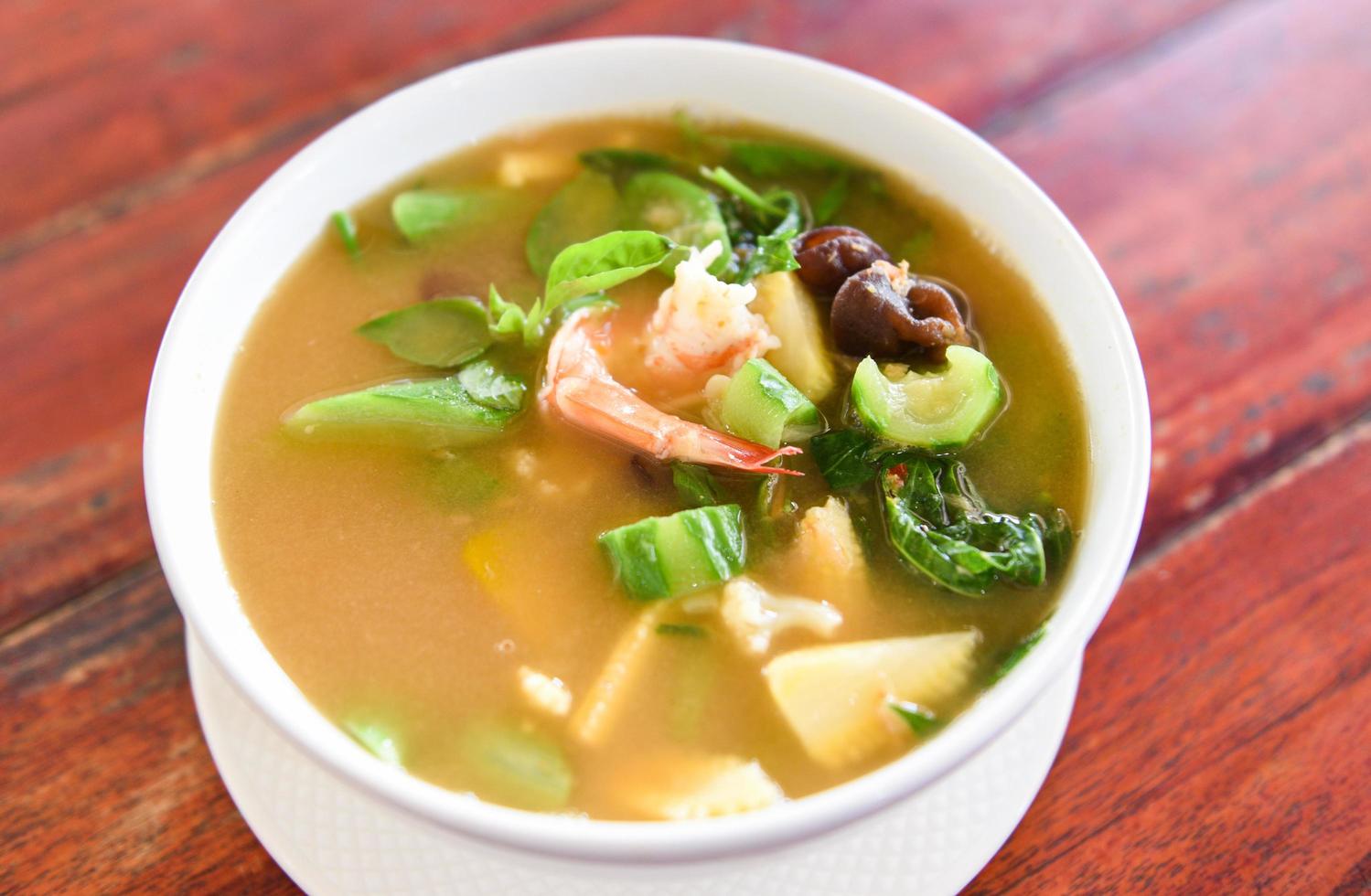 Thai Spicy Mixed Vegetable Soup with Prawns in bowl on wooden table , top view - Thailand food of Asian photo