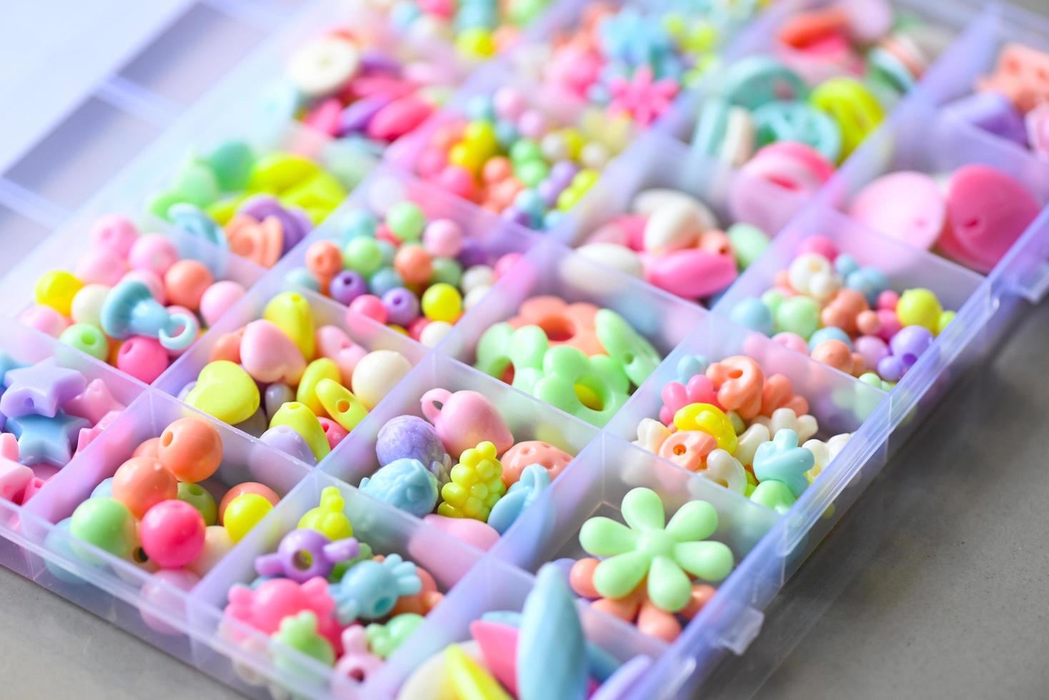 Various Bracelets colorful plastic beads made Cartoon style hand made in box. Variety of shapes and colors to make a bead necklace or a string of beads for women, diy concept photo