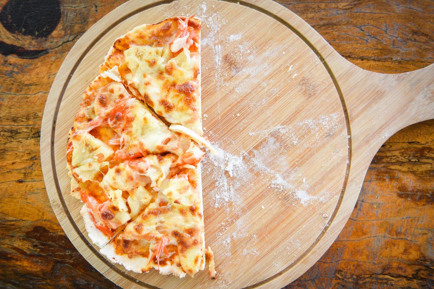 La pizza de repostería casera italiana se cocina comida tradicional: rebanada de queso de pizza en una bandeja de madera y se sirve en una mesa de madera, vista superior foto