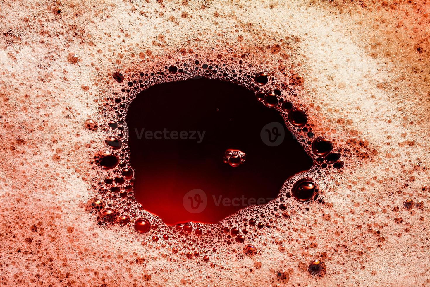 Dark red image of foam on liquid surface. Abstract red foam background. photo