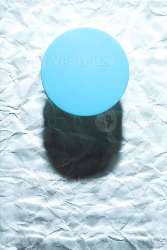 Round blue object on abstract blue background. Minimalist flat lay single object with shadow. photo