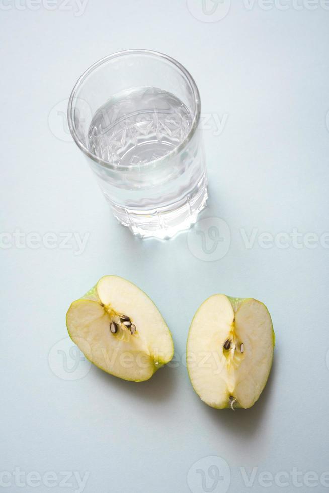 trozos de manzana y un vaso de agua fría con espacio libre para copiar y pegar. estilo de vida saludable y concepto de dieta naturaleza muerta. foto