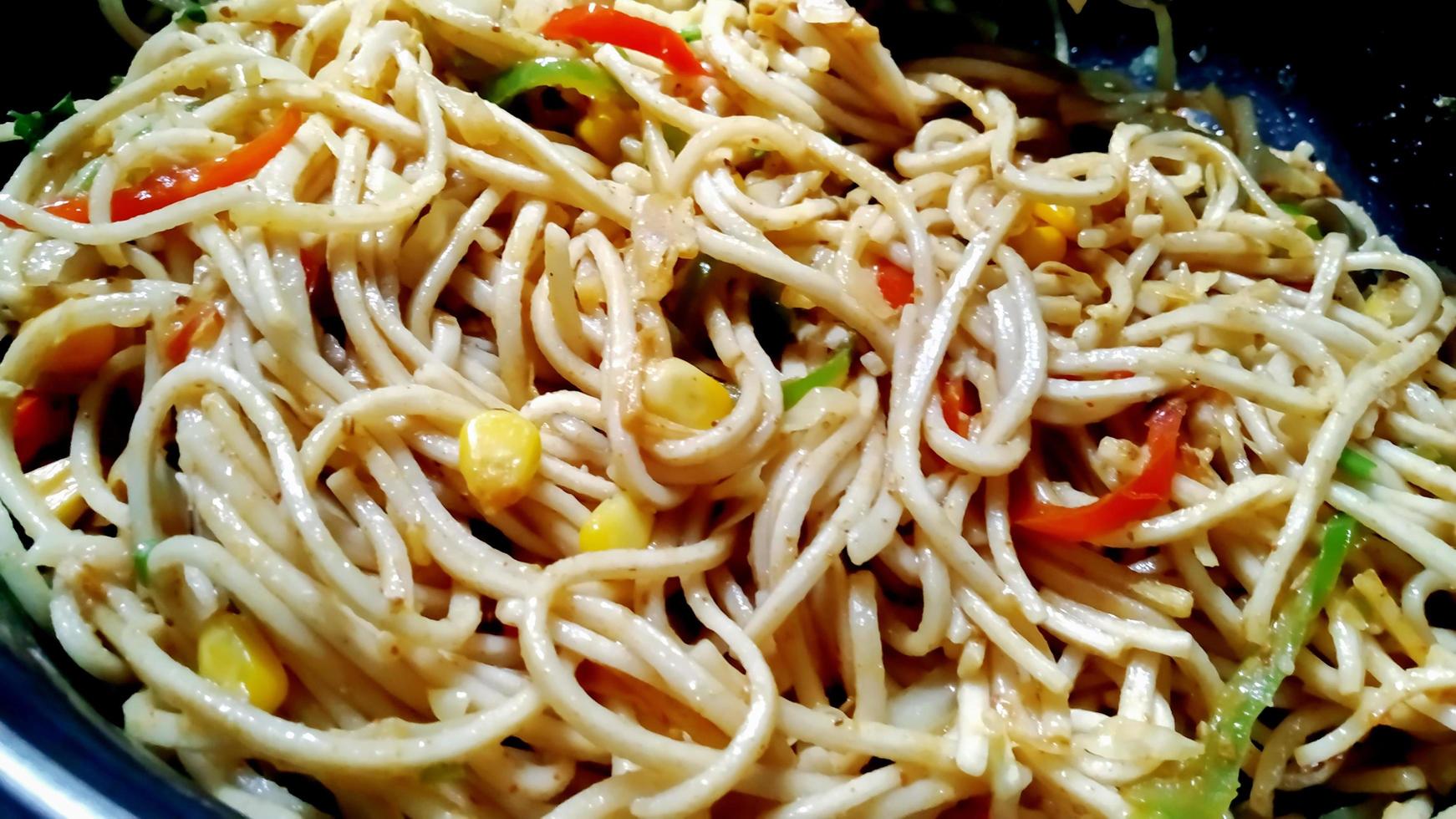 Schezwan Noodles or Szechwan vegetable Hakka Noodles or chow mein is a popular Indo-Chinese recipes, served in a bowl or plate photo