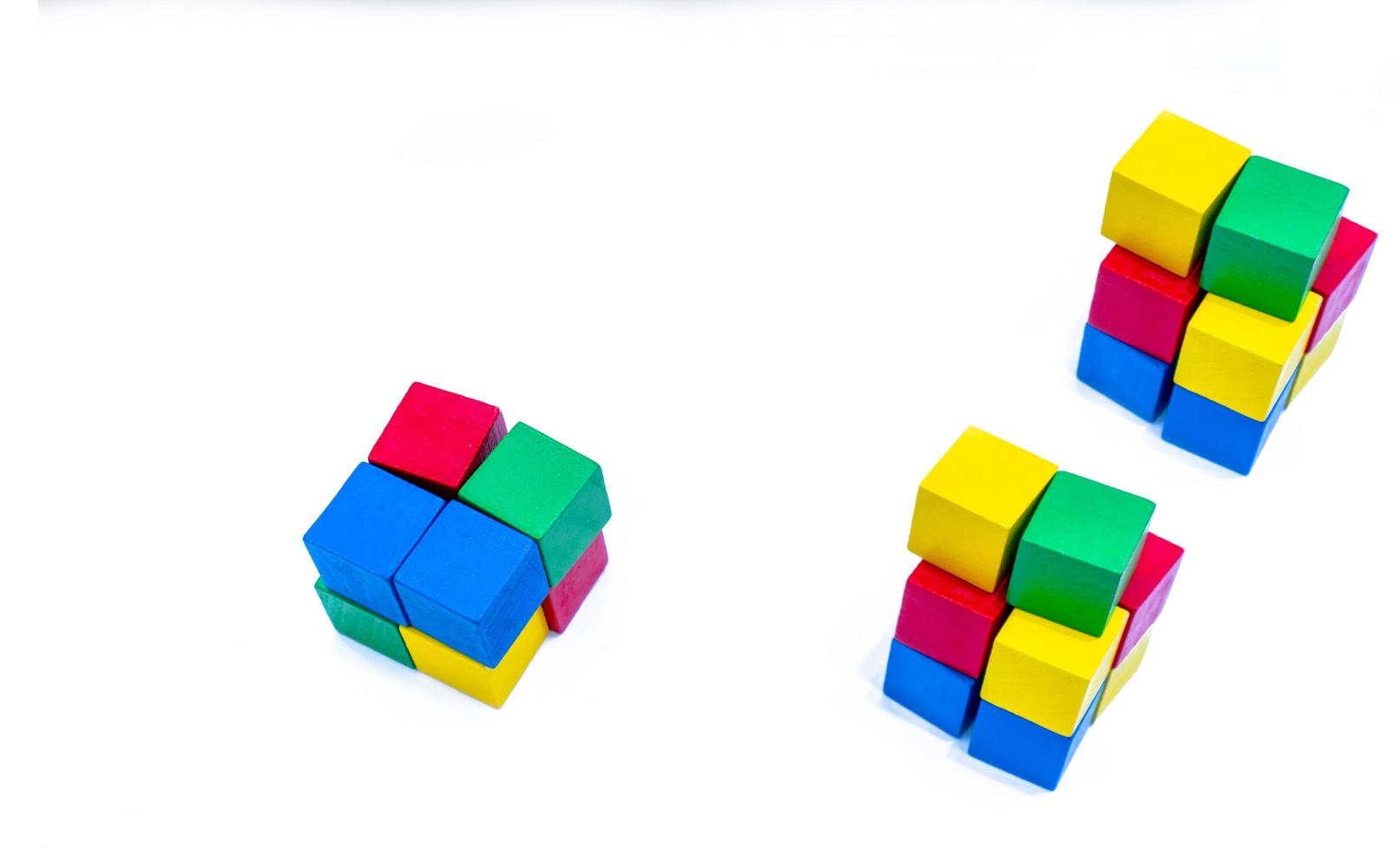 Stack of bright color wooden building block isolated on white background. Blue, red, green, and yellow cube blocks. Kids, baby and child toy help boost fine motor skills and small muscle development photo