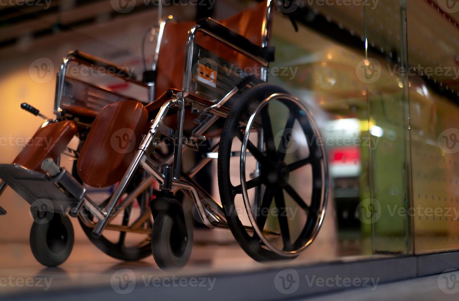 Blurred empty wheelchair near lift in private hospital for service patient and disabled people. Medical equipment in hospital for assistance handicapped people. Chair with wheels for patient care. photo