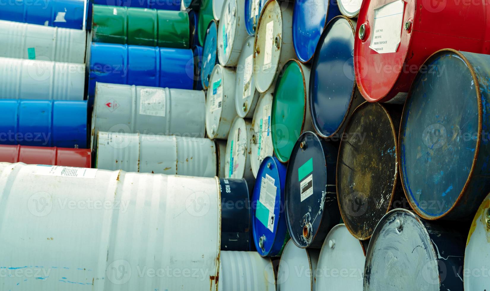 Old chemical barrels. Hazard chemical barrel with warning label. Steel tank of flammable liquid. Empty steel oil tank. Toxic waste warehouse. Hazard waste storage in factory. Metal brent oil drum. photo