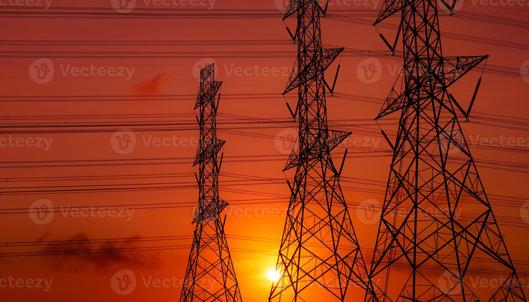 High voltage electric pylon and electrical wire with sunset sky. Electricity poles. Power and energy concept. High voltage grid tower with wire cable. Beautiful red-orange sunset sky. Infrastructure. photo