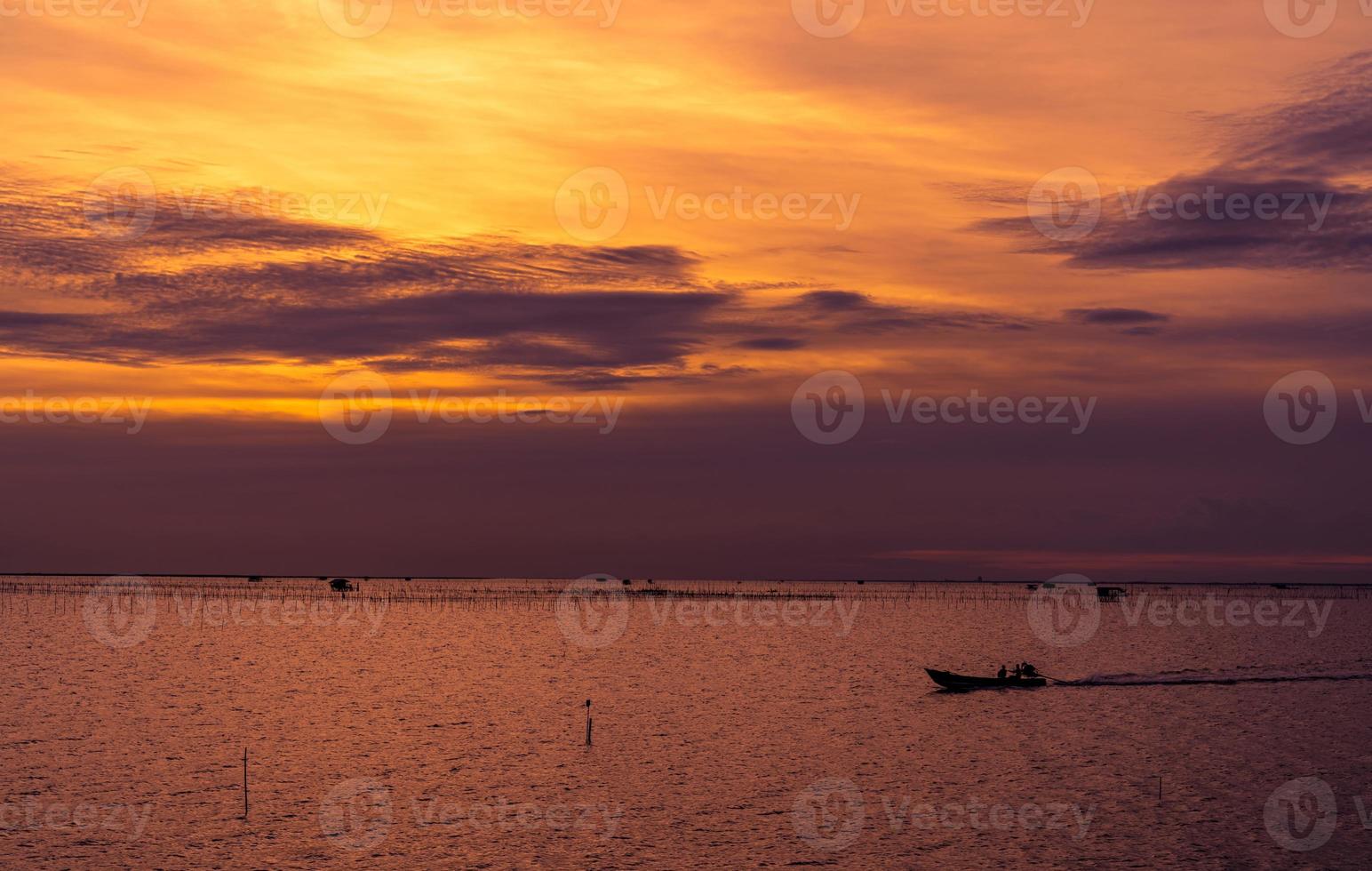 hermoso cielo espectacular puesta de sol. cielo y nubes oscuros y naranjas al atardecer. fondo de naturaleza para un concepto tranquilo y pacífico. mar tropical al atardecer. barco de cola larga navegando por pescador. belleza en la naturaleza. foto