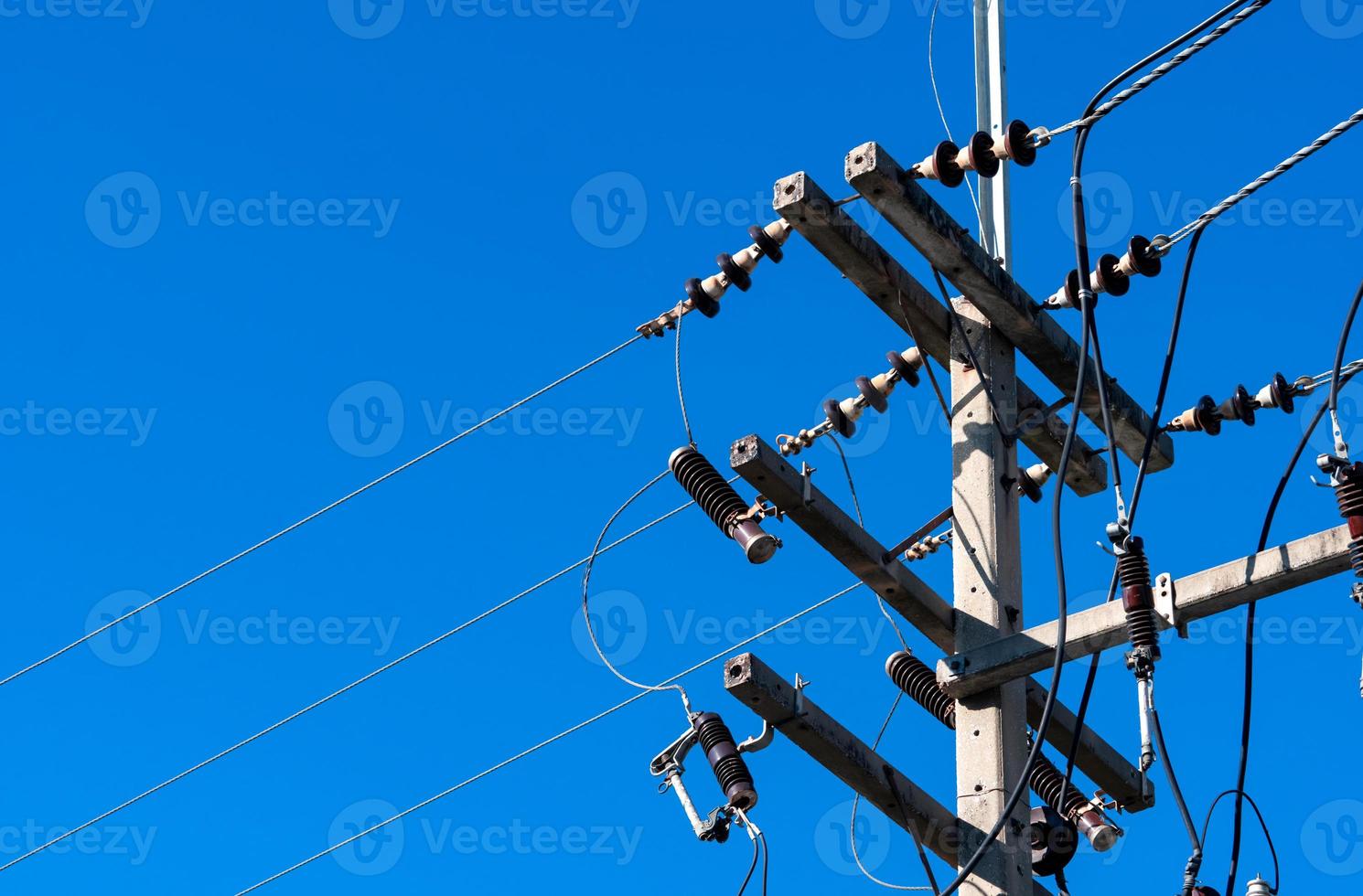 High voltage electric pole and transmission lines with clear blue sky. Electricity pylon. Power and energy engineering system. Danger high voltage tower. Cable wire on electric pylon. Power industry. photo