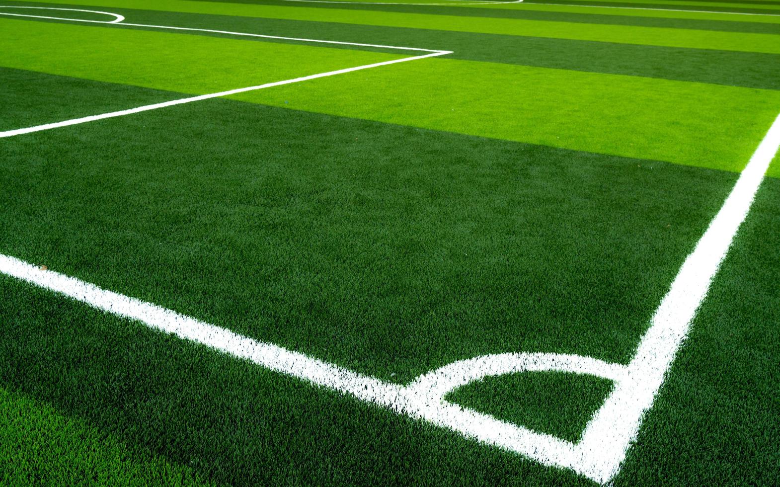 campo de fútbol de hierba verde. campo de fútbol de césped artificial vacío con línea blanca. vista desde la esquina del campo de fútbol. fondo deportivo foto