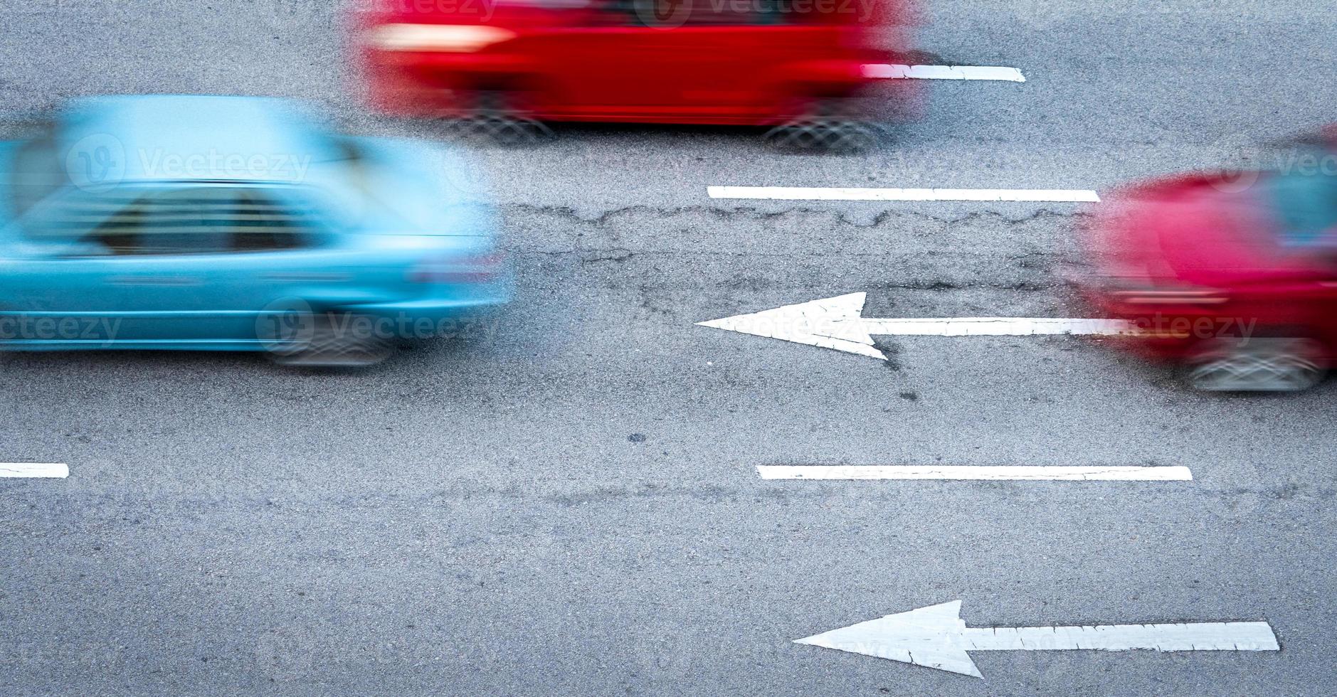 Red and blue car fast moving on asphalt road in the city. Blurred motion of fast speed compact car on asphalt road. Urban transport with rush hour concept. Travel by car. Car fuel consumption concept. photo