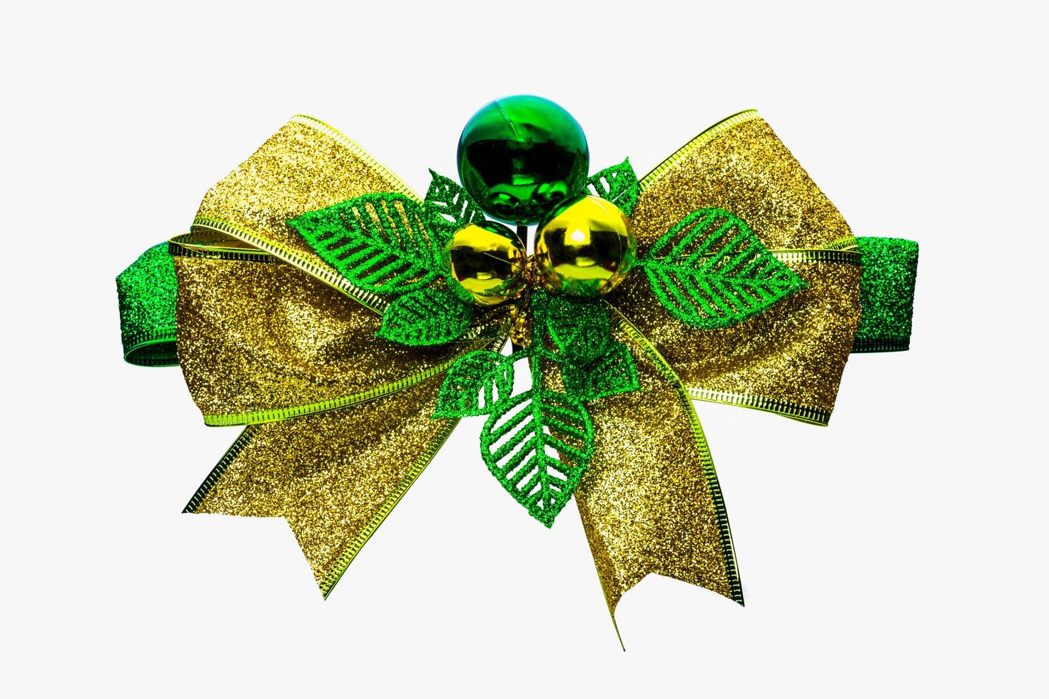 Shiny green and gold Christmas bow and ball isolated on white background with copy space. Ribbon for gift or present concept. Christmas decorative ribbon and Christmas ornament concept. photo