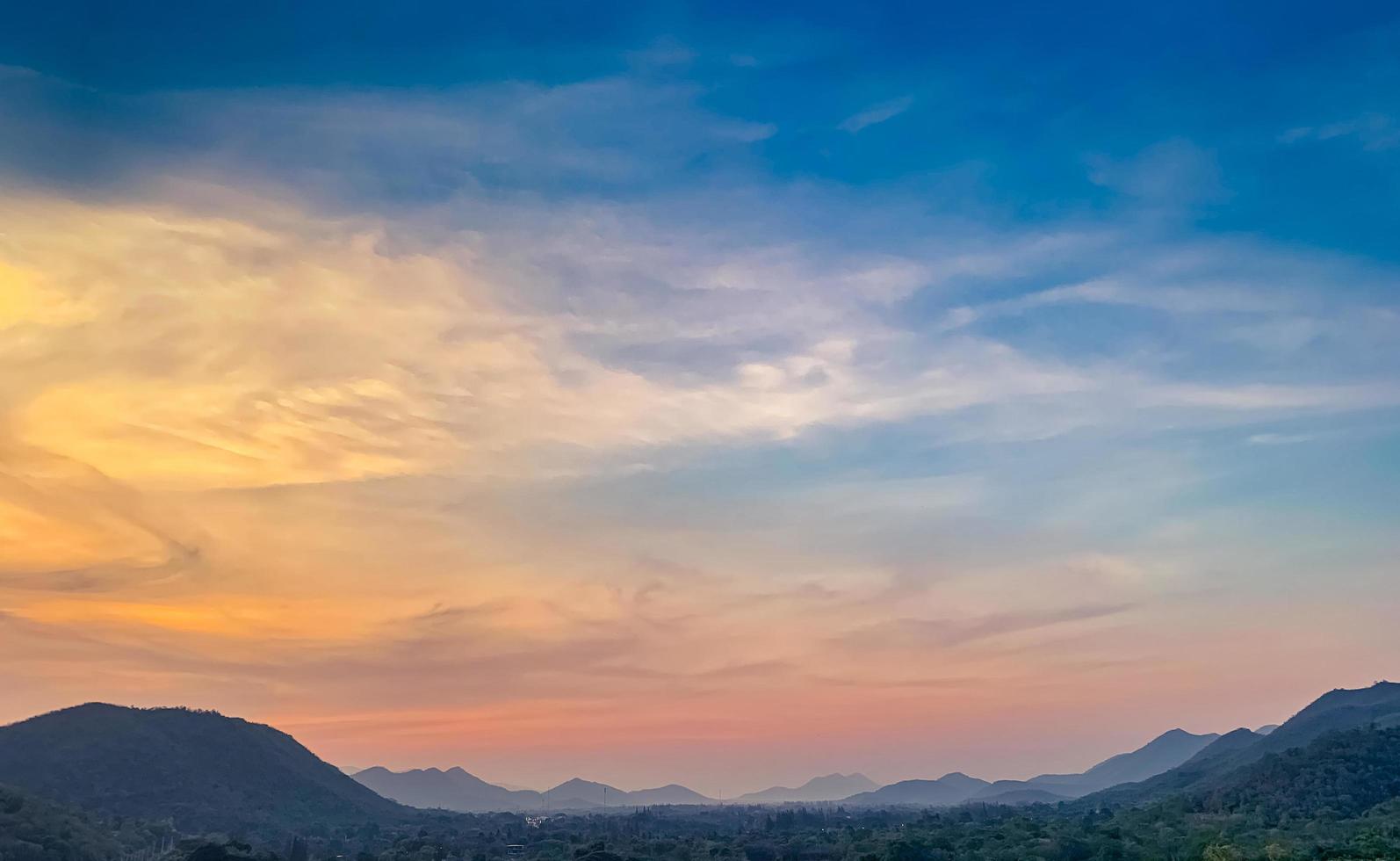 Landscape of mountain range with beautiful sunset sky. Mountain with fog in the evening. Colorful sky and clouds at sunset. Mountain valley in Thailand. Scenery of mountain layer at dusk. photo