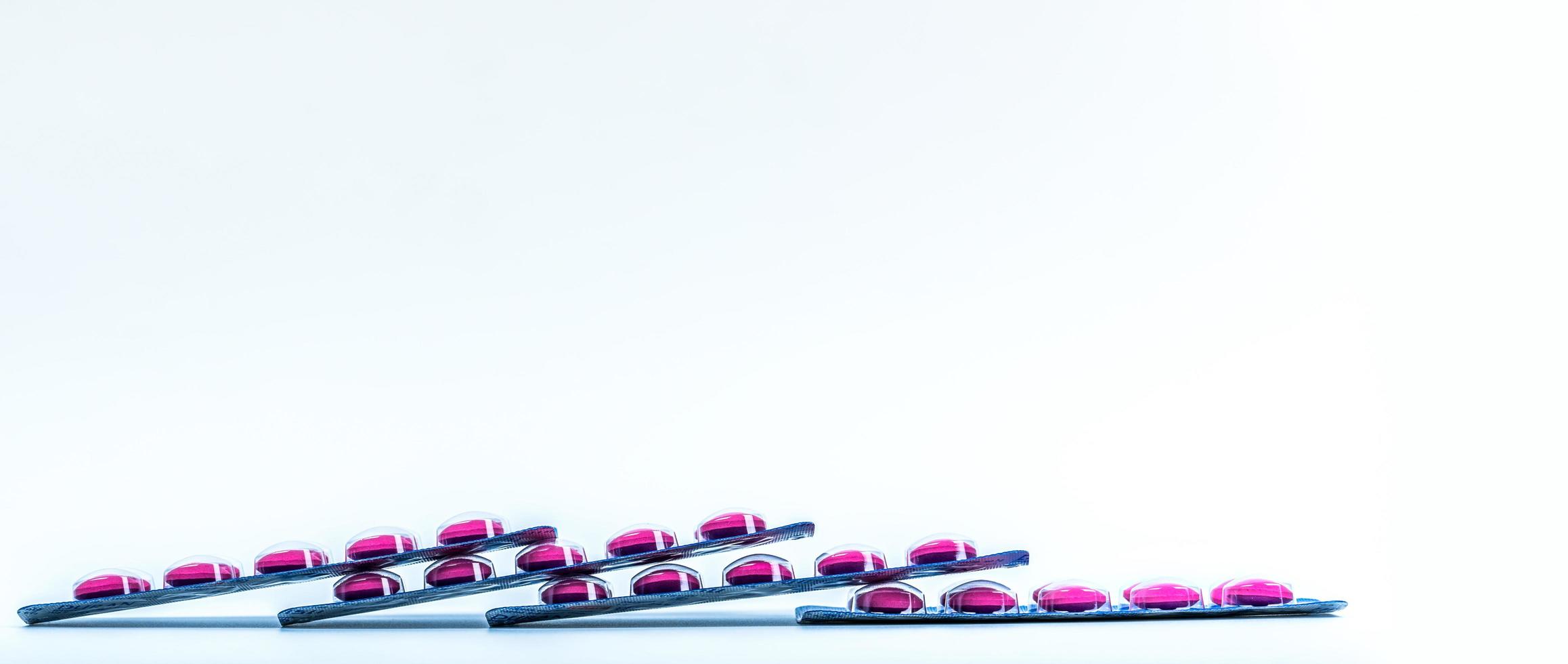 Side view of pink tablets pill in blister pack isolated on white background with copy space. Ibuprofen for relief pain, headache, high fever and anti-inflammatory. Painkiller pills. Healthcare concept photo