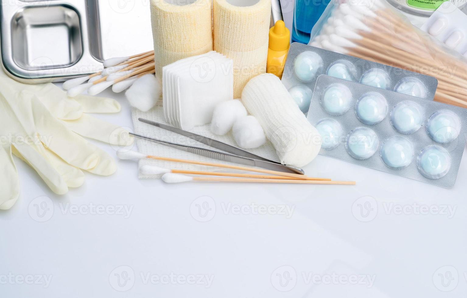 Wound care dressing set. Forceps, cotton stick, conform bandage, elastic cohesive retention bandage, cotton ball with alcohol, latex disposable gloves, and povidone-iodine. Medical supply for nurses. photo