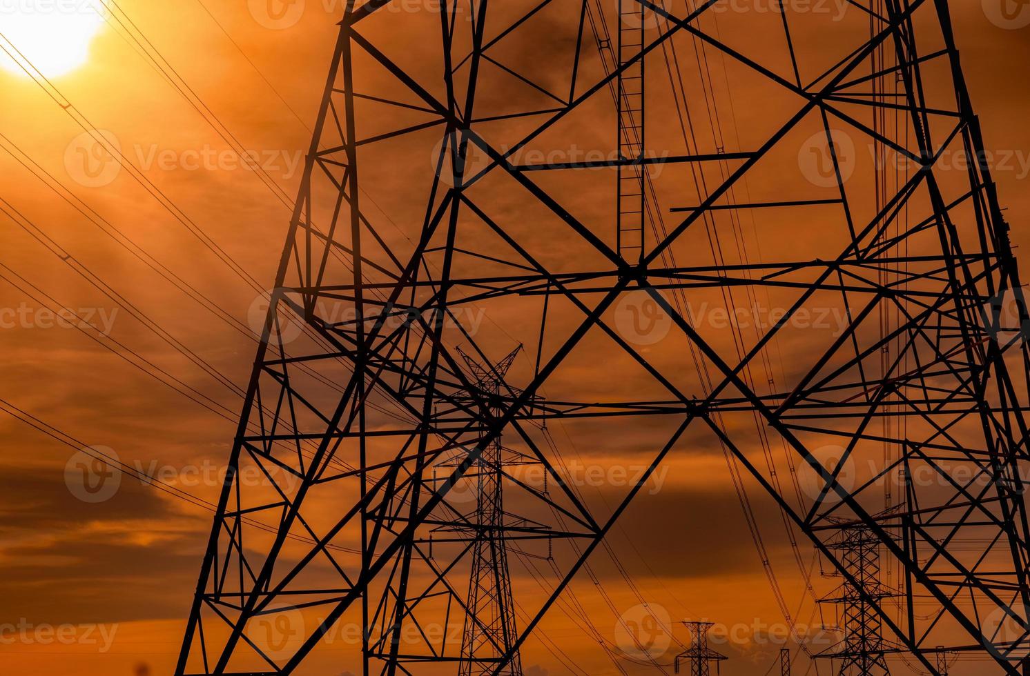 High voltage electric pole and transmission lines in the evening. Electricity pylons at sunset. Power and energy. Energy conservation. High voltage grid tower with wire cable at distribution station. photo