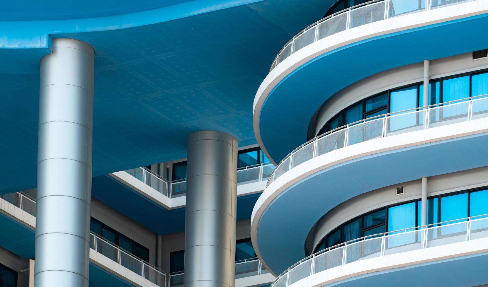 primer edificio blanco y azul con ventana de cristal. arquitectura moderna. edificio exterior. detalles arquitectónicos del edificio moderno. fachada del edificio de oficinas. concepto de construcción de propiedades. foto