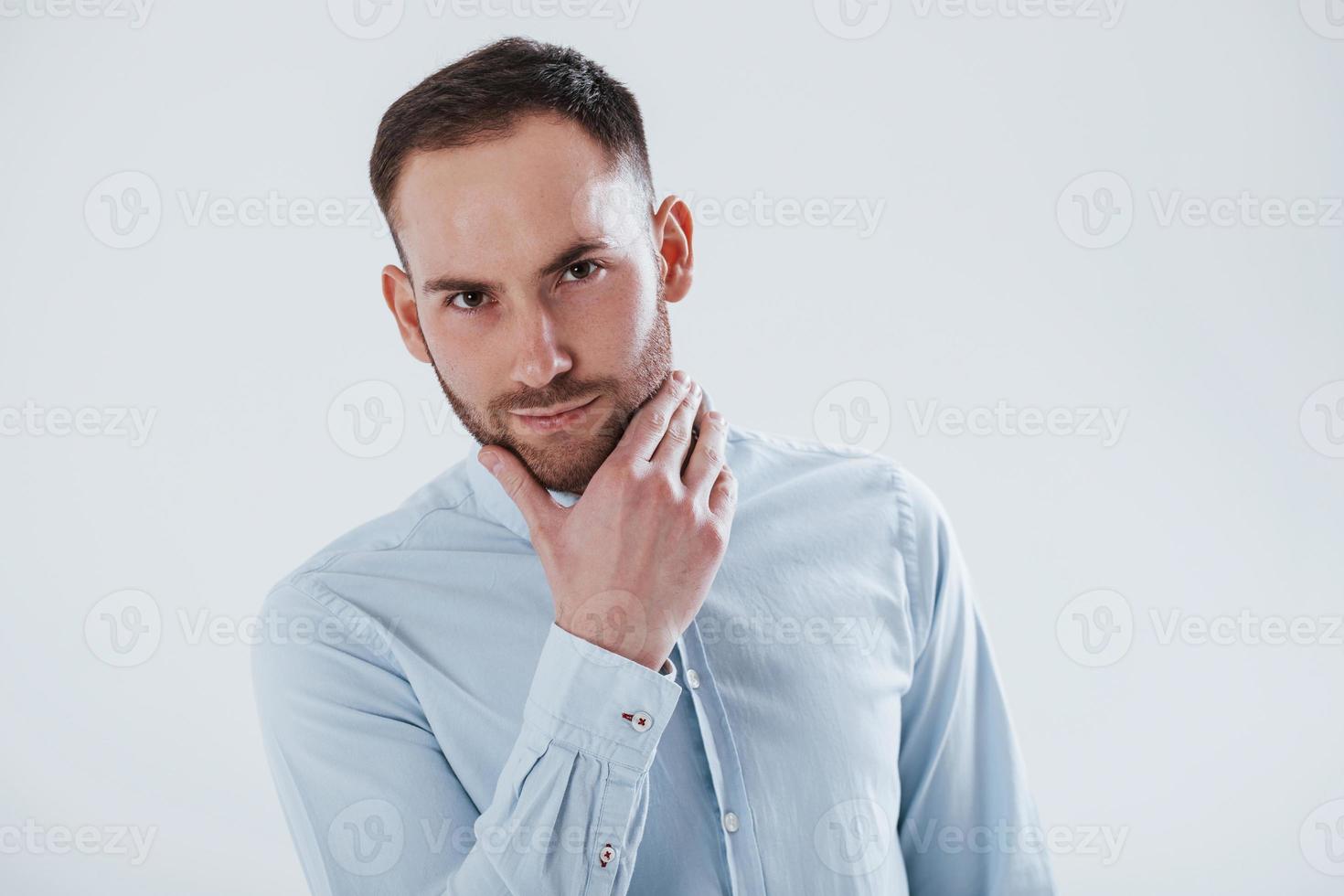 mirada confiada de persona exitosa. el hombre vestido con ropa oficial se alza contra un fondo blanco en el estudio foto