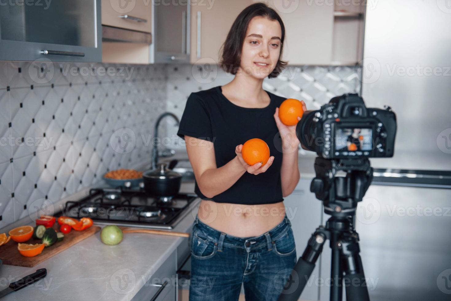 Expensive camera. Girl in the modern kitchen at home at her weekend time in the morning photo