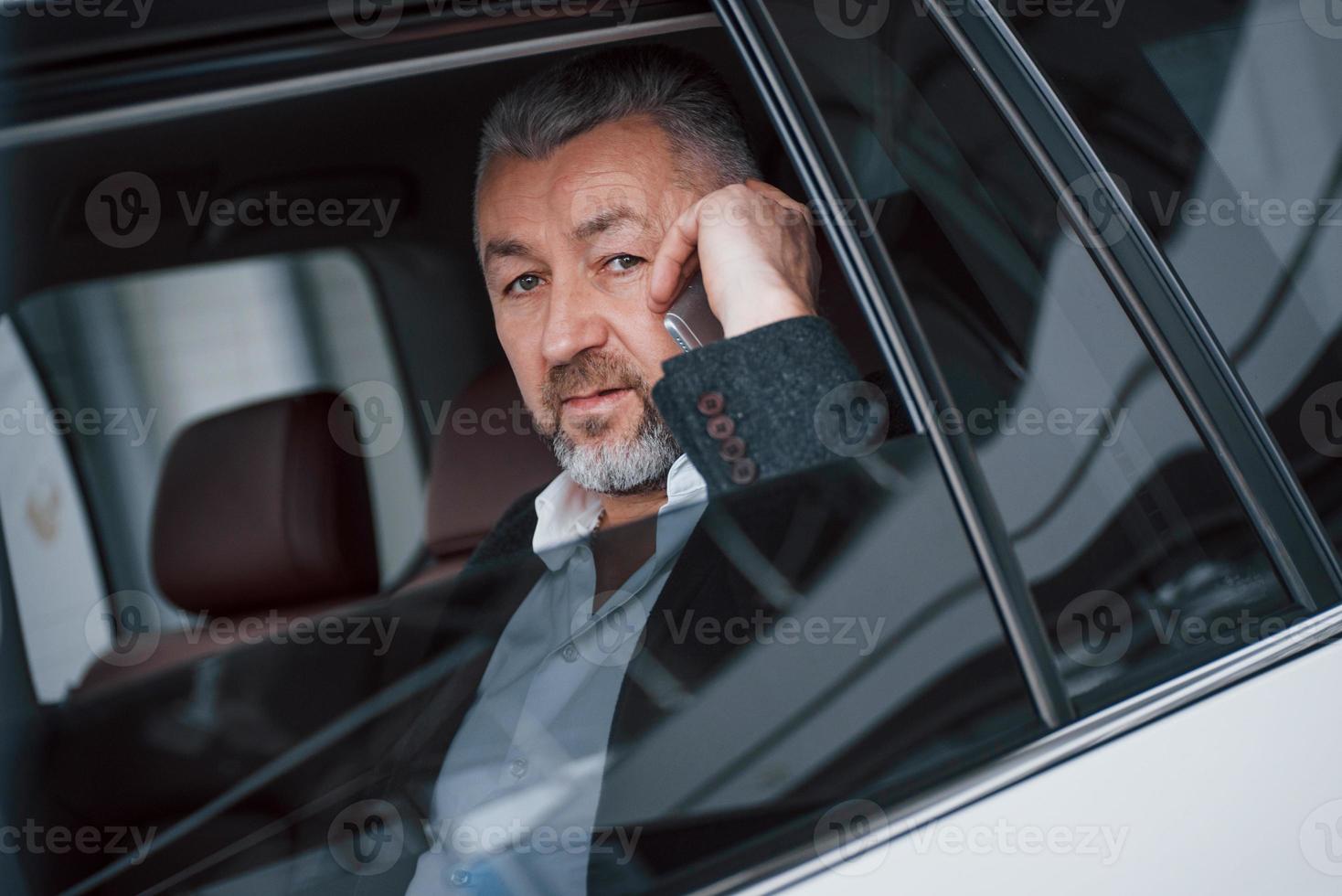 Serious busy boss. Business talk in the car while stopped. Having conversation about new deals photo