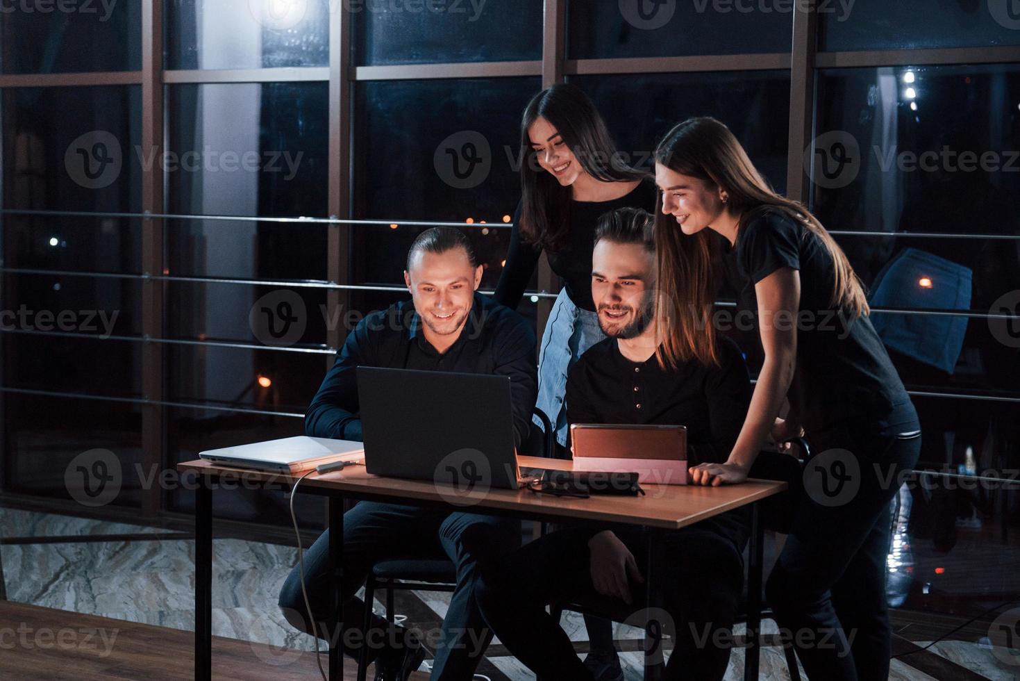 Sleep for the weak. Team of young business people works on their project at night time in the office photo
