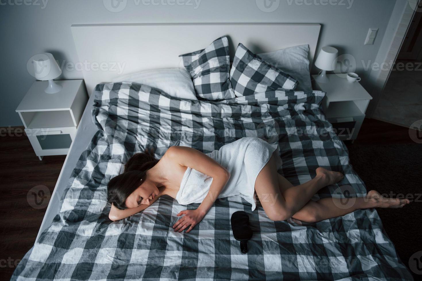 Need another five minutes to sleep. Pretty young woman lying on the bed at morning time in her room photo