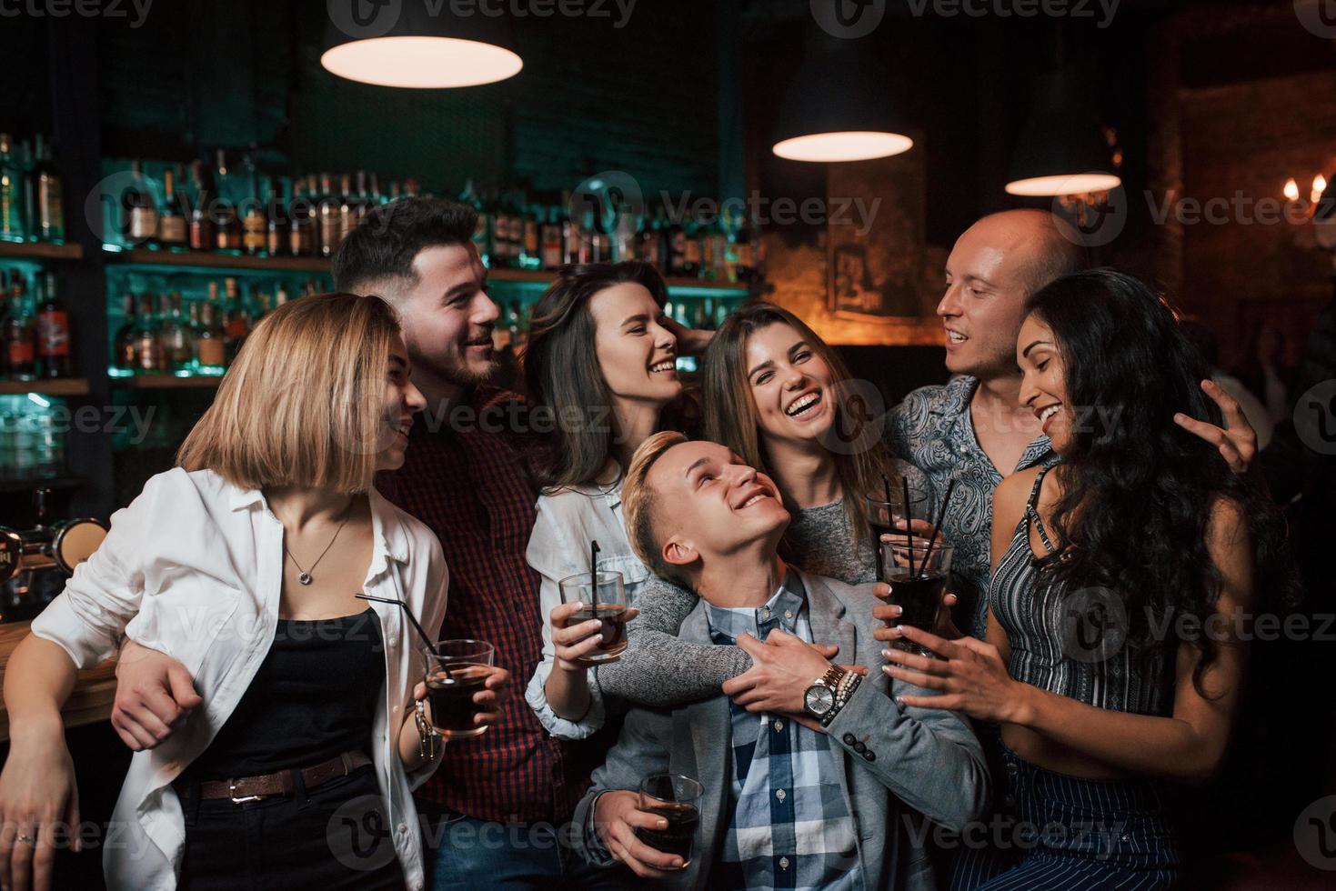 no te preocupes esta noche. hermosos jóvenes tienen fiesta junto con alcohol en el club foto