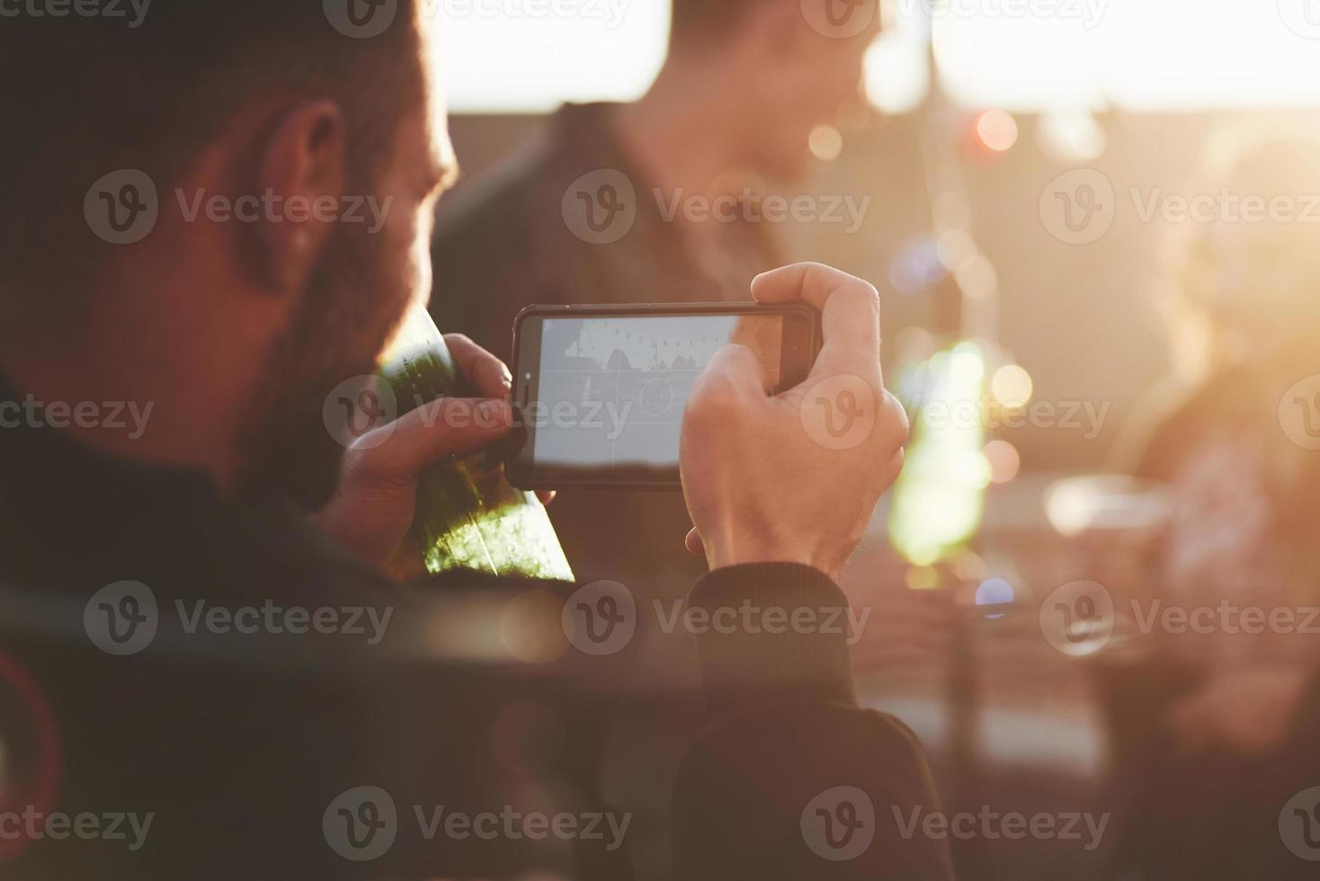 I'm going to capture, be sure you are ready. Taking picture of friends at the rooftop at nice sunny autumn day photo