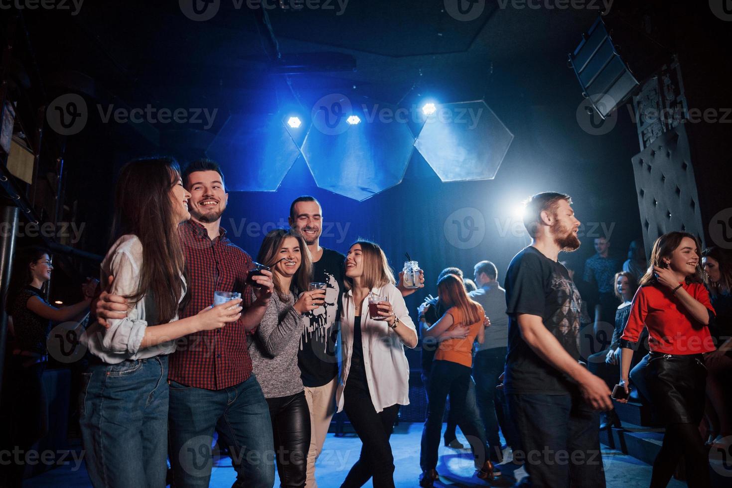 de pie en la pista de baile. hermosos jóvenes tienen fiesta junto con alcohol en la discoteca foto