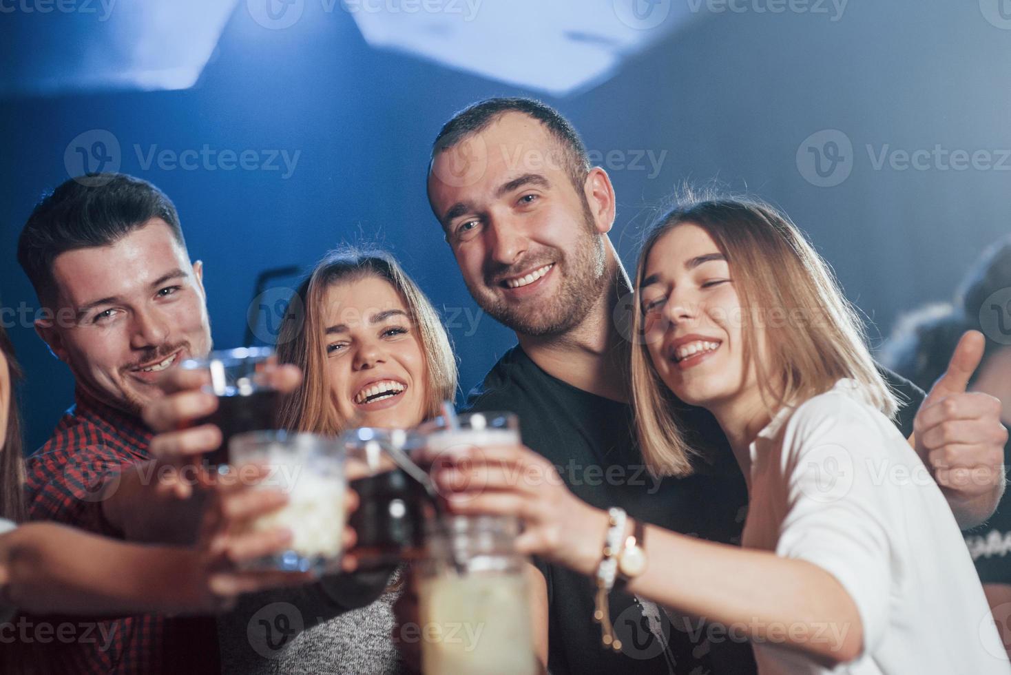 ocio. gente feliz bailando en el club nocturno de lujo junto con diferentes bebidas en sus manos foto