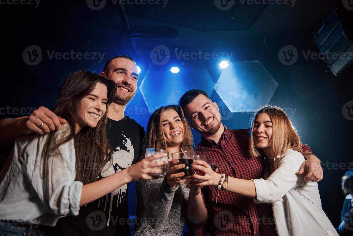 Making toast and hug each other. Beautiful youth have party together with alcohol in the nightclub photo