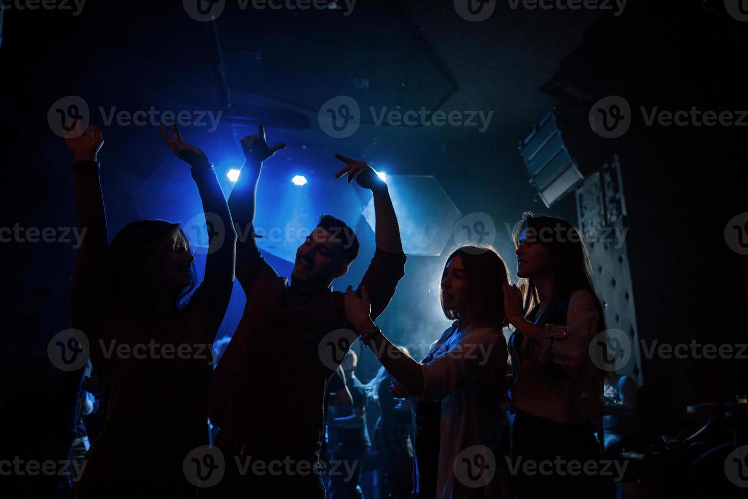 juventud feliz. grupo de personas que disfrutan bailando en la discoteca con hermosas luces foto