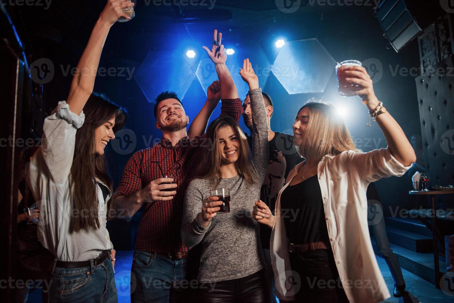 gente feliz bailando en el club nocturno de lujo junto con diferentes bebidas en sus manos foto